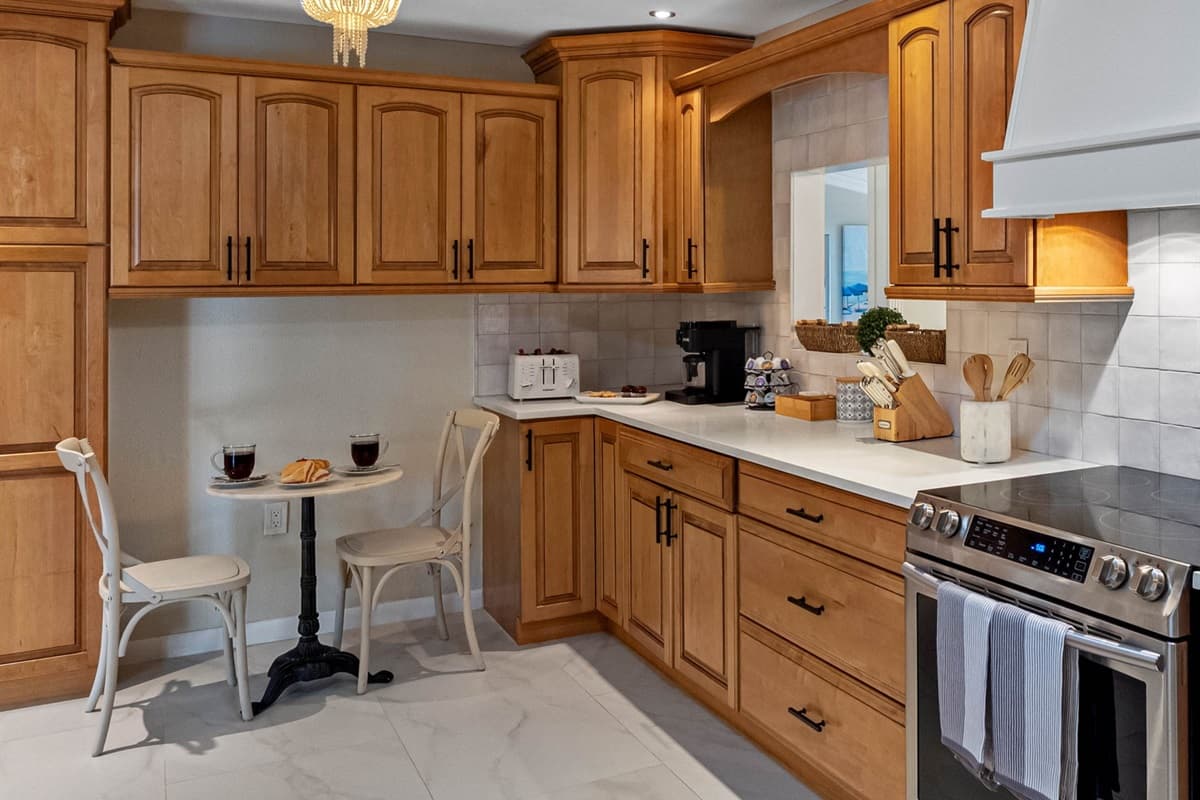 This kitchen features warm wood cabinetry, sleek quartz countertops, and stainless-steel appliances for a perfect blend of style and function.