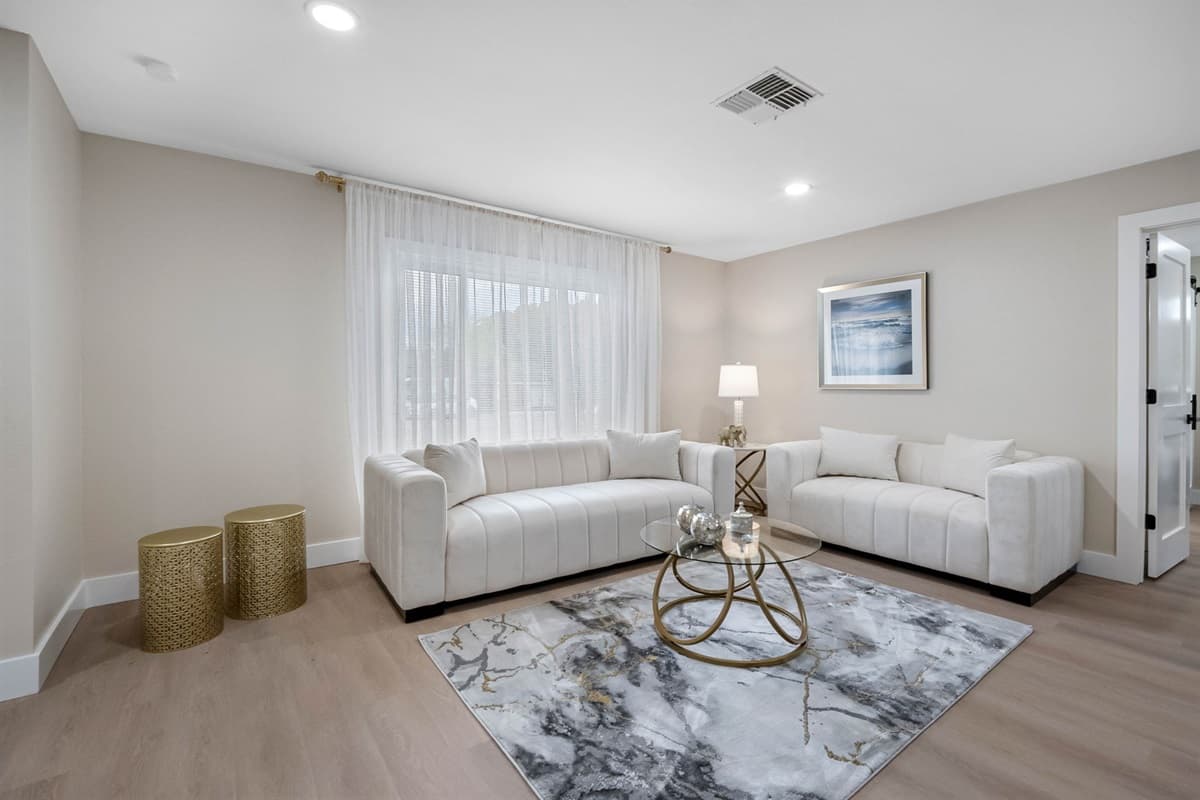 This bright, open living room features plush white sofas, soft lighting, and a calm coastal vibe perfect for unwinding after a day exploring Tampa Bay.
