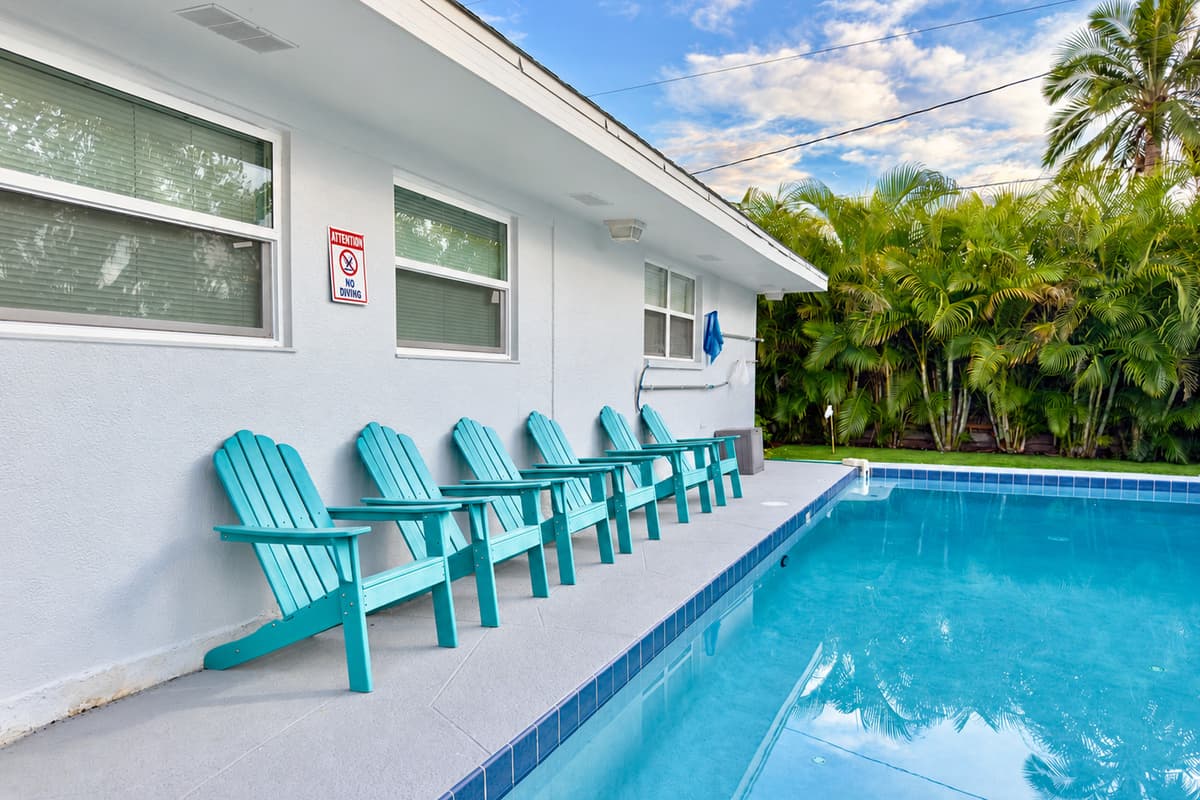 The crystal-clear pool is the centerpiece of this backyard retreat, surrounded by palms for a resort feel.