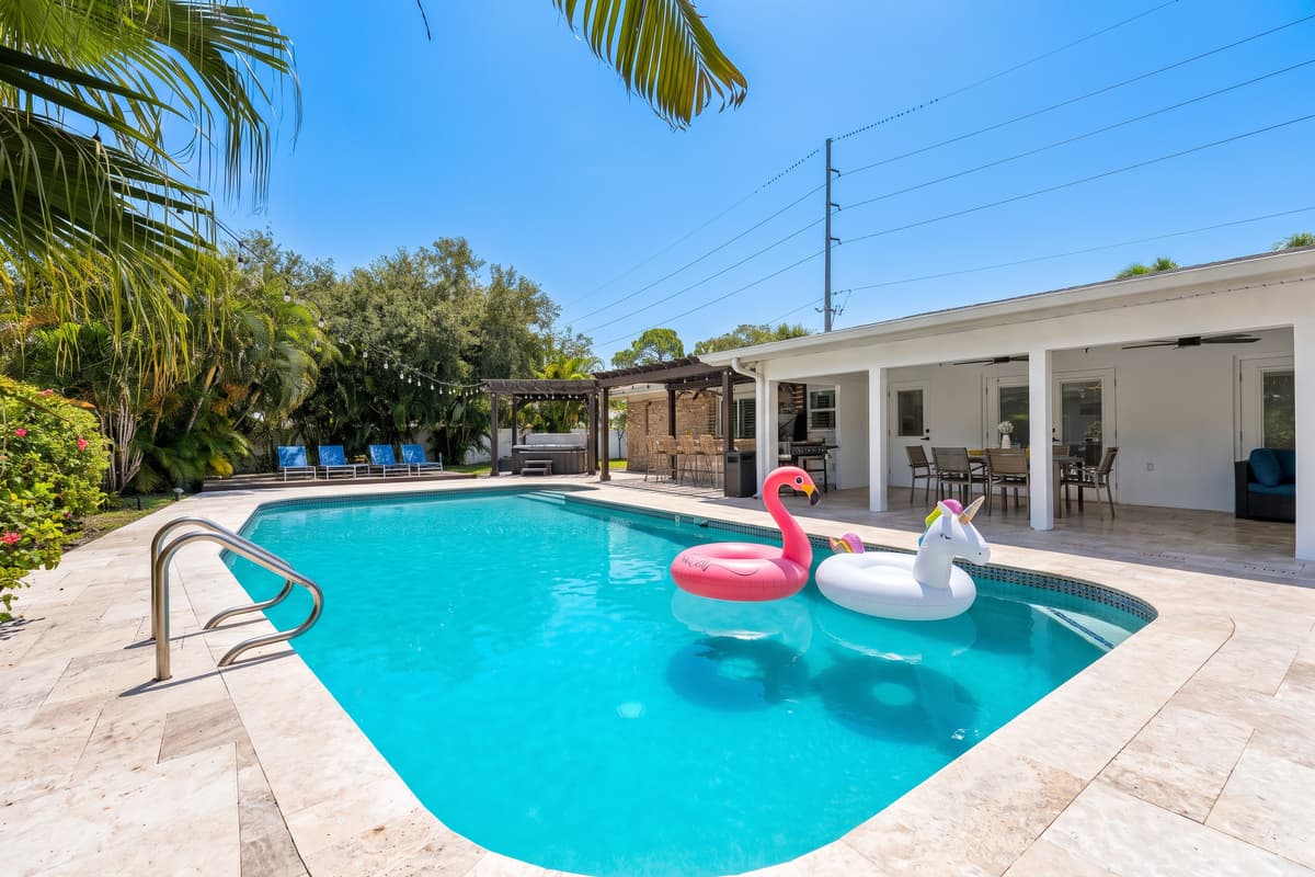 The pool stretches toward the covered lanai, showing off just how much of the home opens onto outdoor living