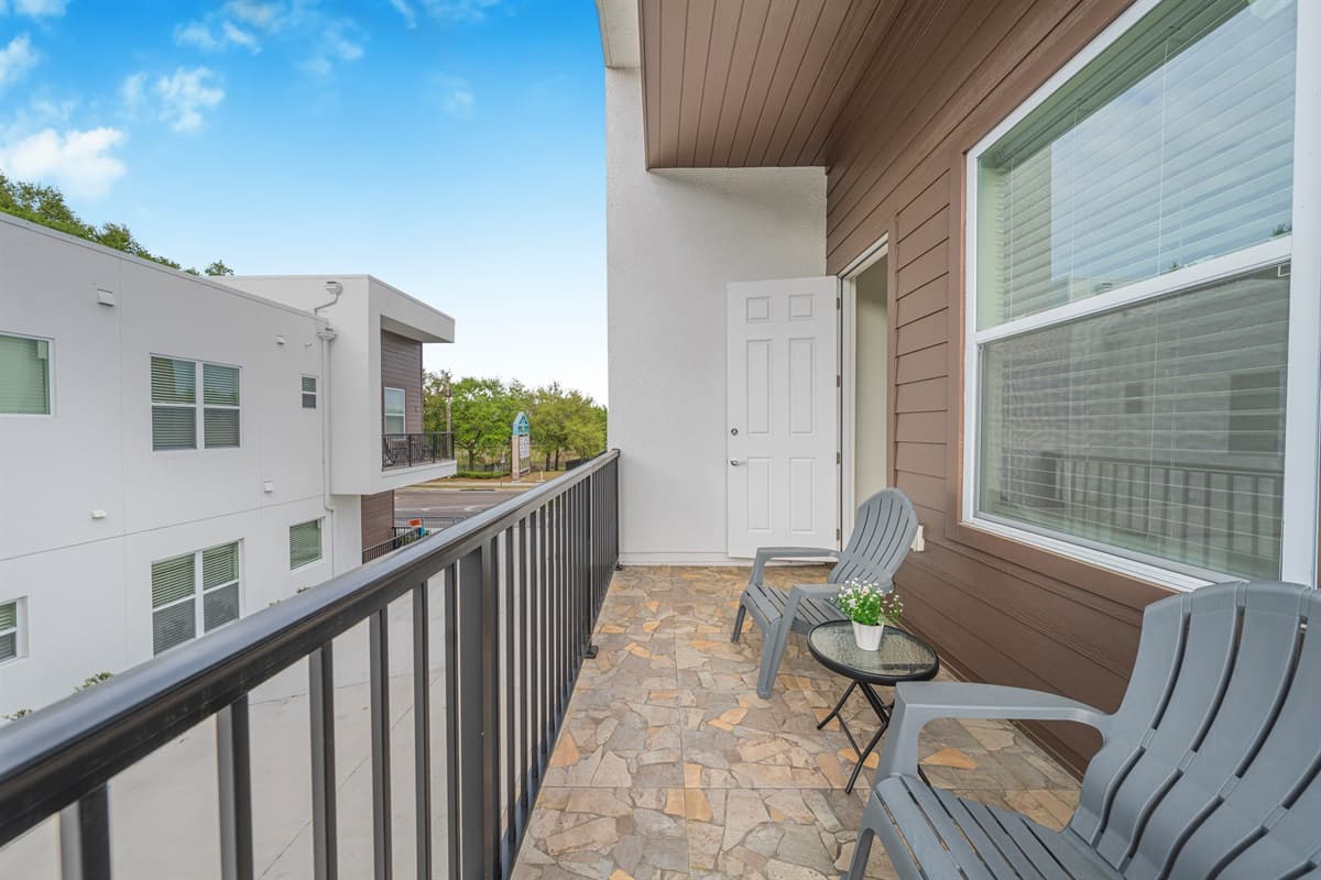 Spacious private balcony with comfortable seating—perfect for morning coffee or unwinding while enjoying the fresh air and neighborhood views.