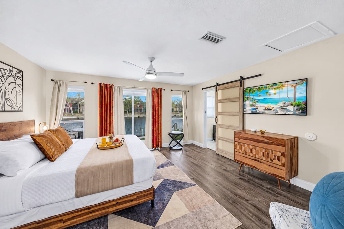 Stylish primary bedroom offering plenty of space, natural light, and tranquil water views.