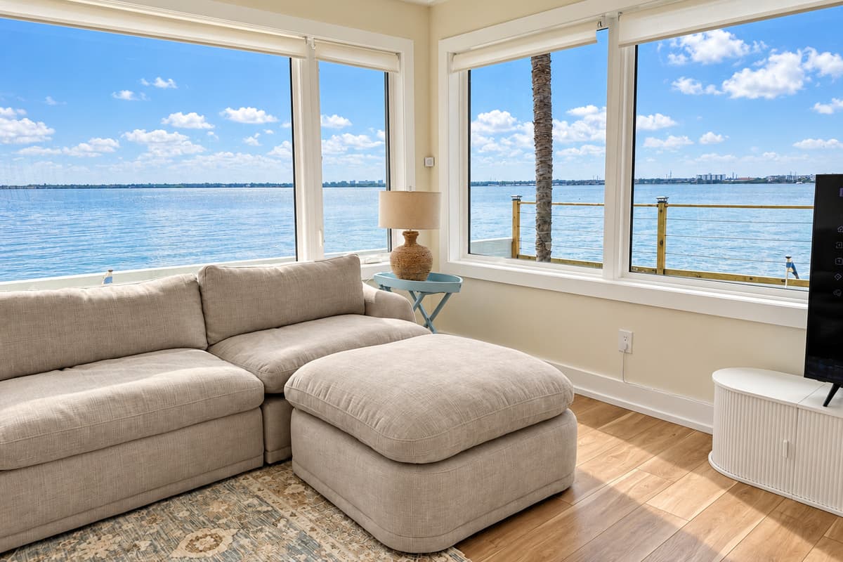 Waterfront living room with comfortable seating and wide water views.