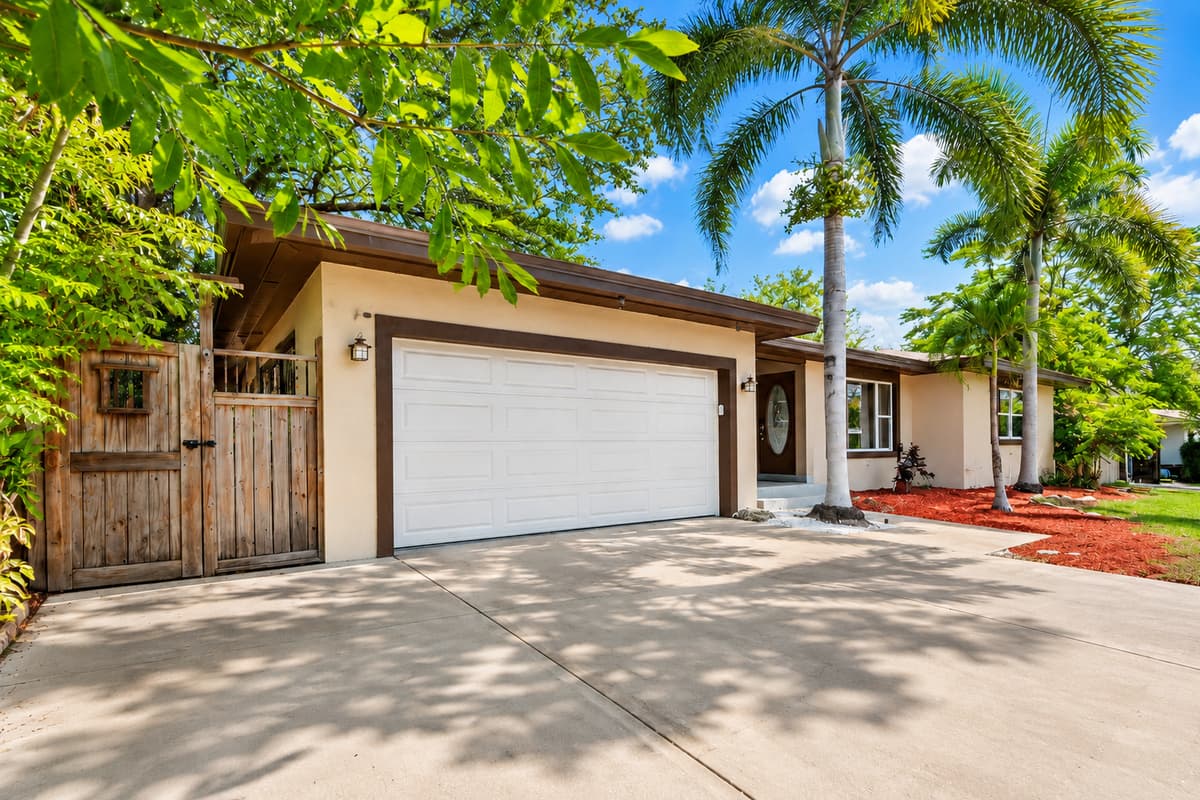 Spacious driveway with ample parking and beautiful palm tree landscaping.