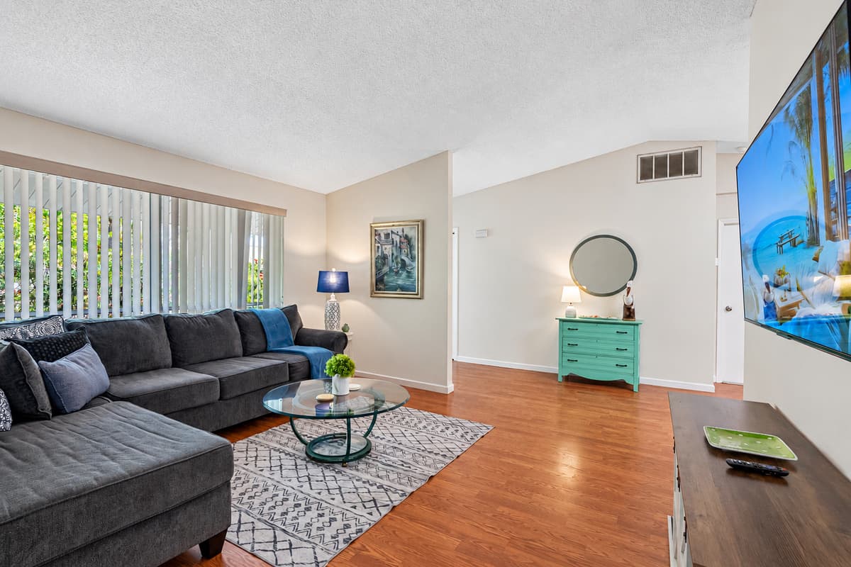 ​The living room is thoughtfully designed to provide a comfortable and entertaining environment, featuring a state-of-the-art Smart TV and a plush lounging couch.