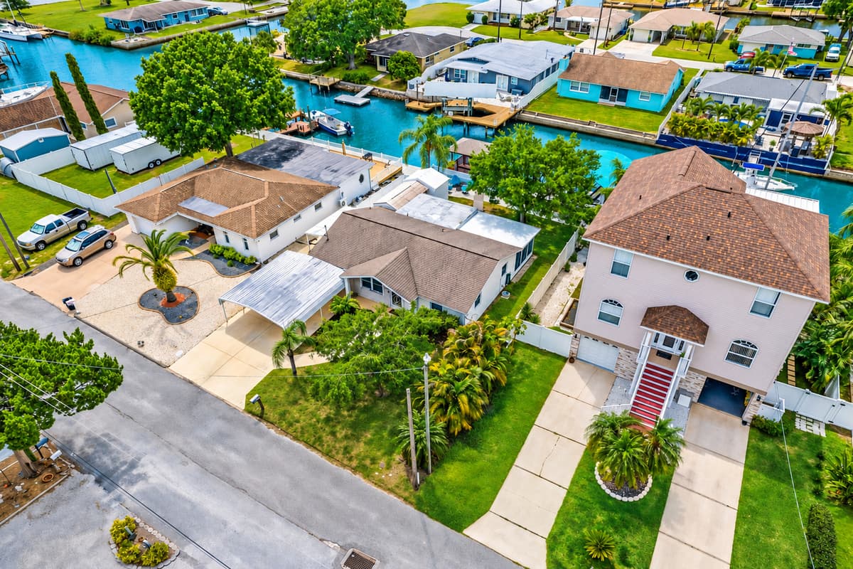 Aerial front view of our stunning property showcasing our spacious driveway and parking. The property is surrounded by trees and is fully fenced. If you are interested in this property, send us an inquiry now!