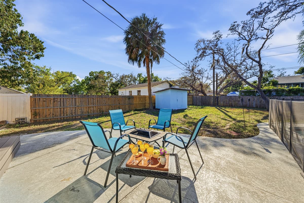 Patio seating area overlooking a large fenced backyard.