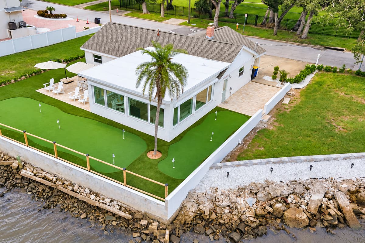 Palm trees, putting green and bay views. The sunroom opens to a turf green framed by palms and the seawall. Golf, relax or just watch the boats go by.