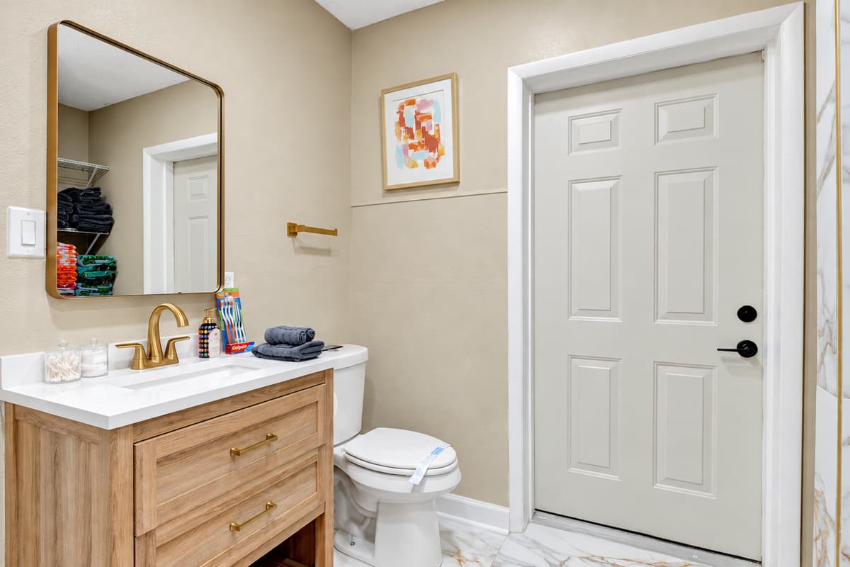 Step into pure elegance and refinement in our bathroom, where creamy marble and gilded accents come together to create a sanctuary of opulence.