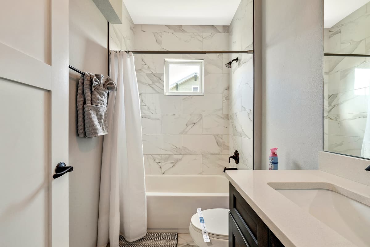 The spacious tub, inviting and deep, beckons you to immerse yourself in a cocoon of warmth and tranquility.