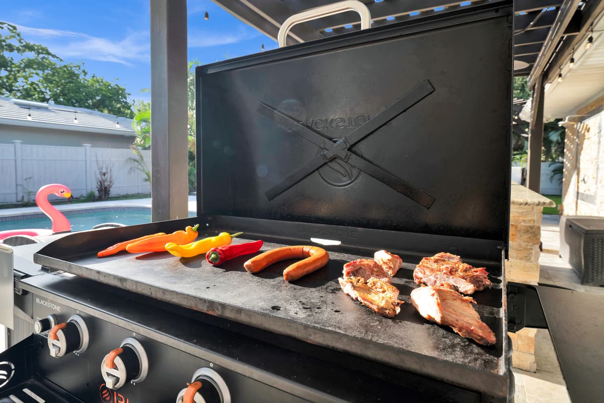 The built-in grill comes ready for a cookout, hot dogs and burgers sizzling just steps from the pool