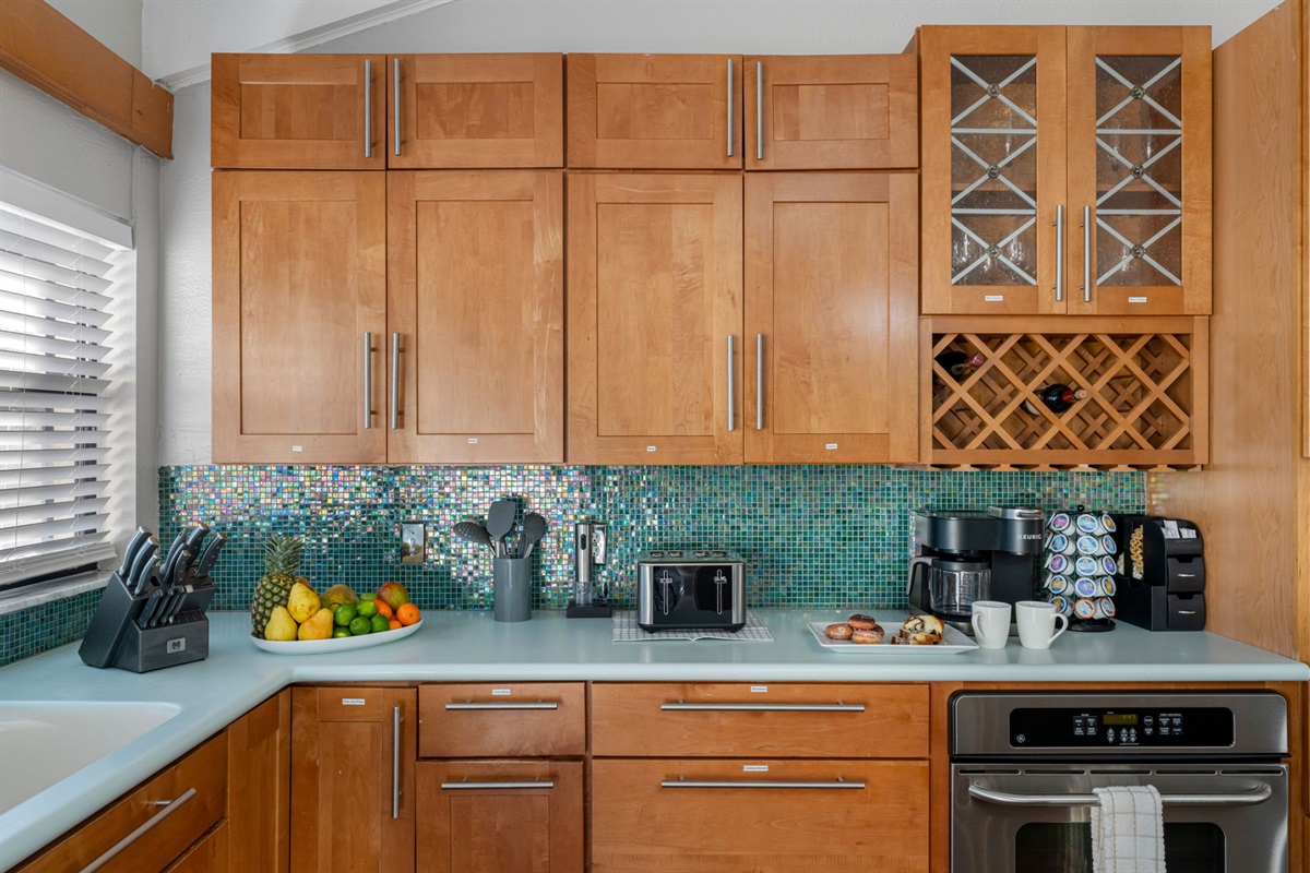 The colorful mosaic backsplash adds personality and a pop of charm to this inviting kitchen.