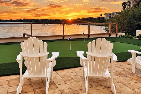 The best seats for golden hour. Adirondack chairs face the sun setting over the bay and putting green. Grab a drink and settle in for the show.