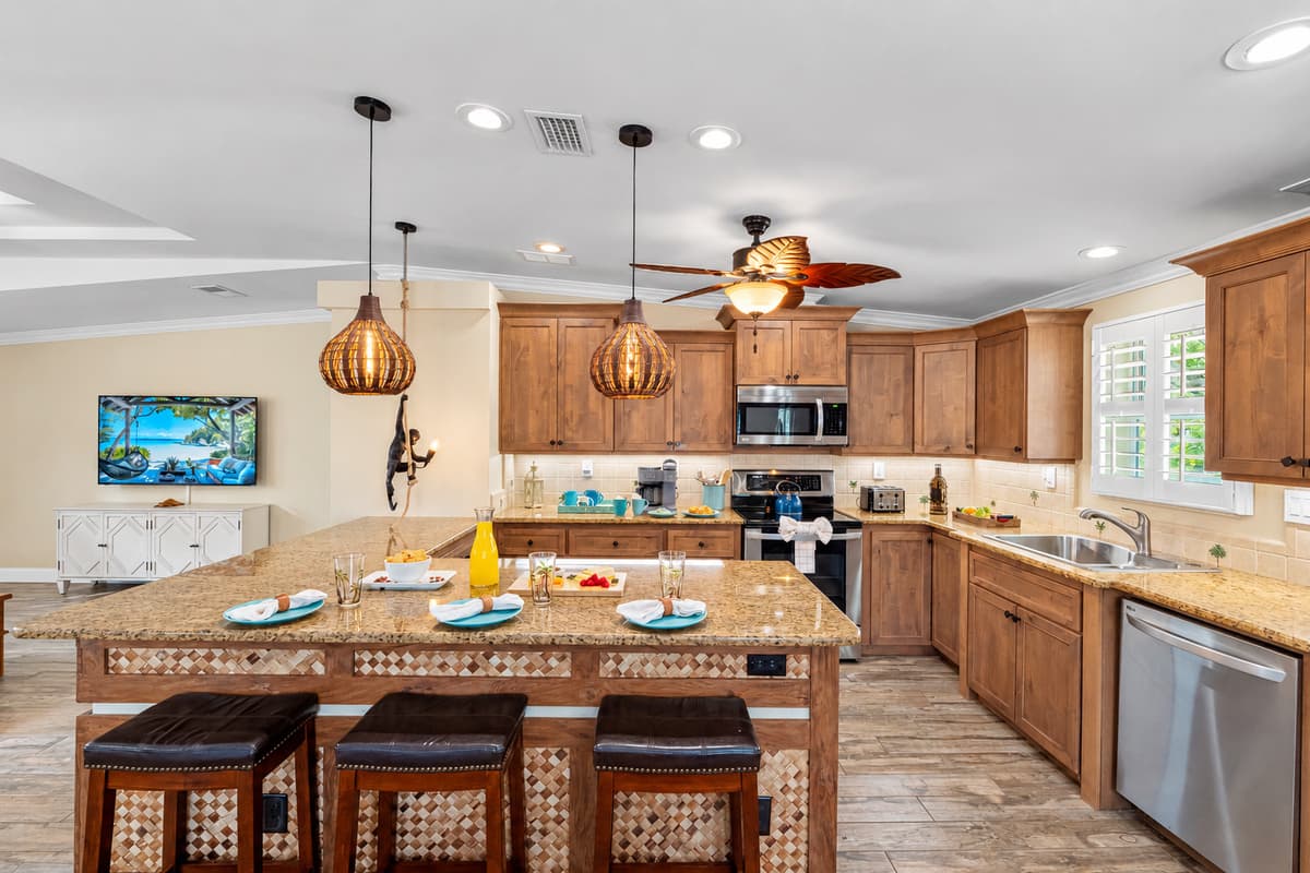 Warm wood tones and elegant lighting make this kitchen feel cozy yet luxurious, offering everything needed for a comfortable stay.