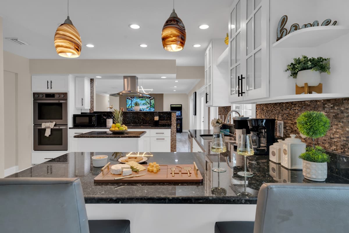 009-A charcuterie board styled on the black granite island under warm pendant lighting hints at the good times this kitchen is made for