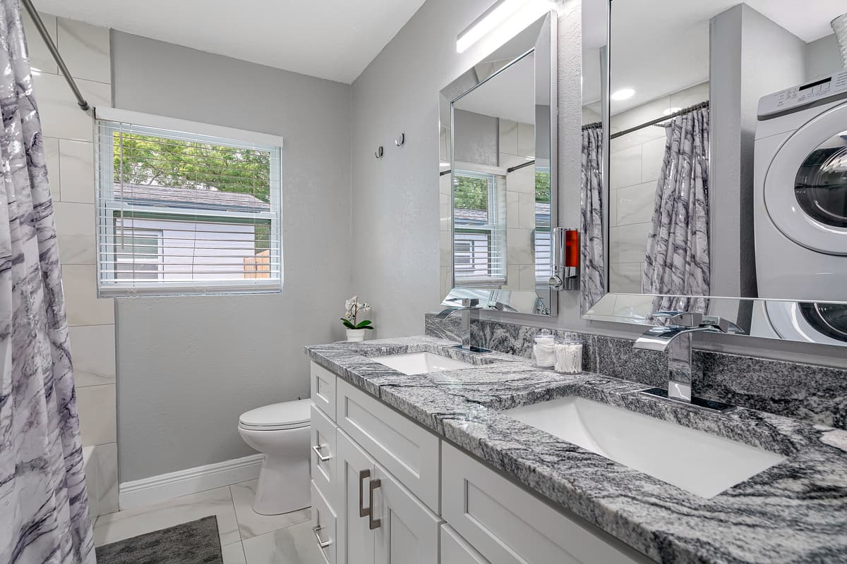 This stunning bathroom has a bathtub, shower, toilet and his and hers sink. It is also equipped with full sized washer and dryer. If you have any questions, send us a message!