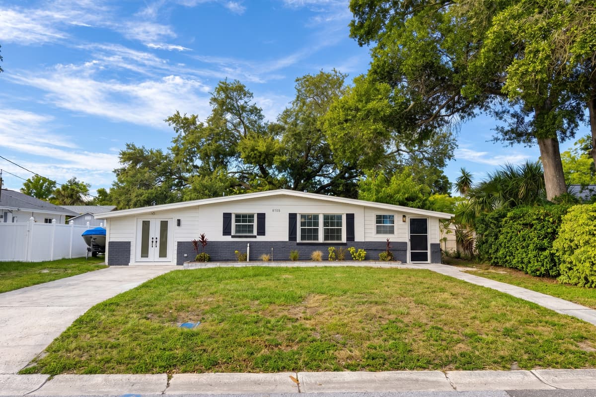 Blue skies, big oaks, your Tampa home base. Single-story home on a quiet residential street, with a wide front lawn and mature trees. No stairs to climb, an easy setup for families, groups and longer stays.