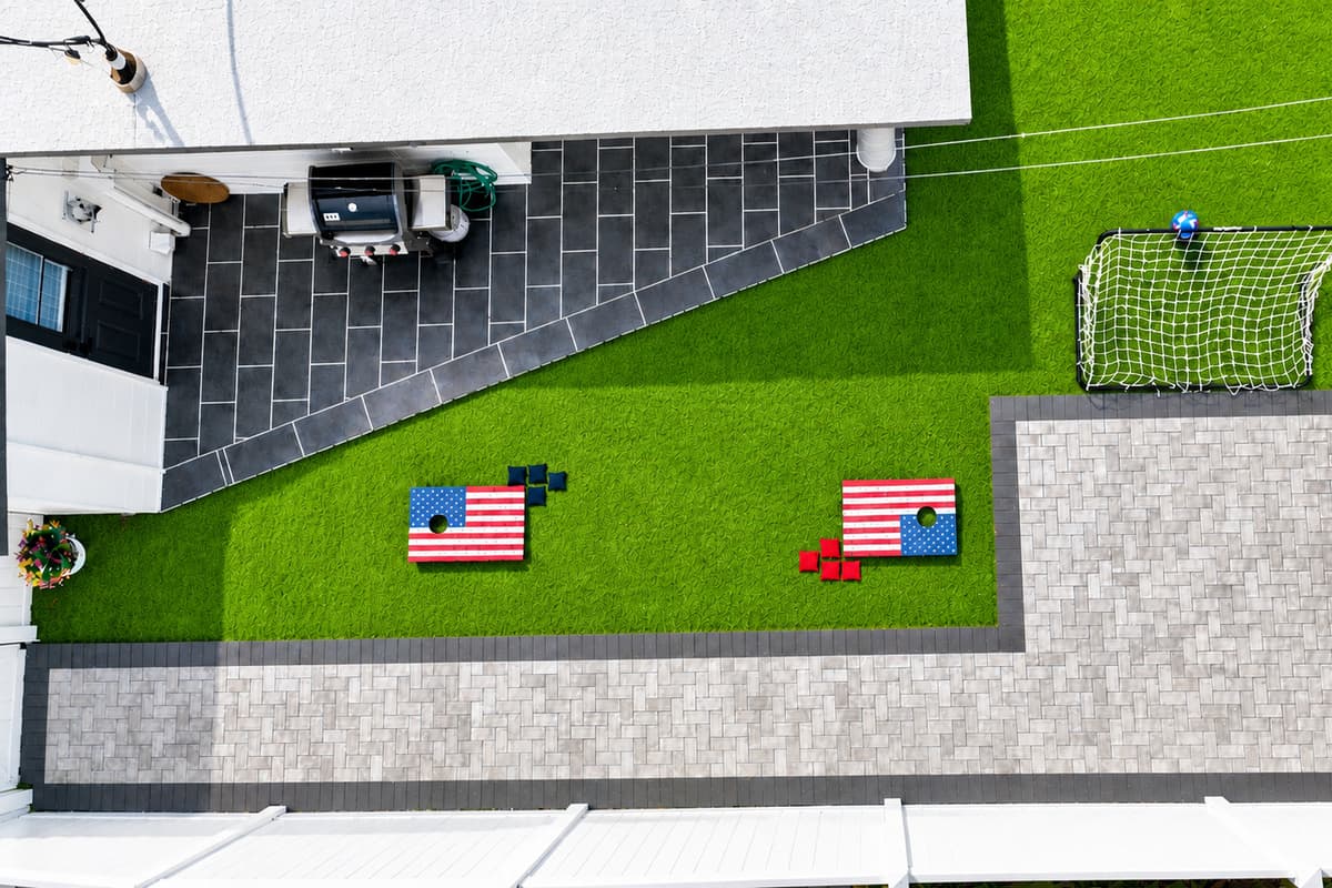 Top-down aerial shot of the backyard entertainment area with lawn games and patio.