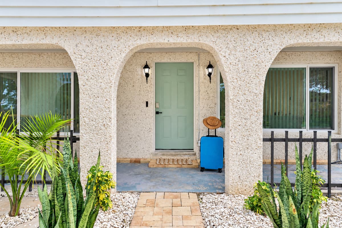 Your front door is waiting. An arched porch, coastal green door and tropical plants welcome you in. Drop the bags, take a breath and let the vacation begin.