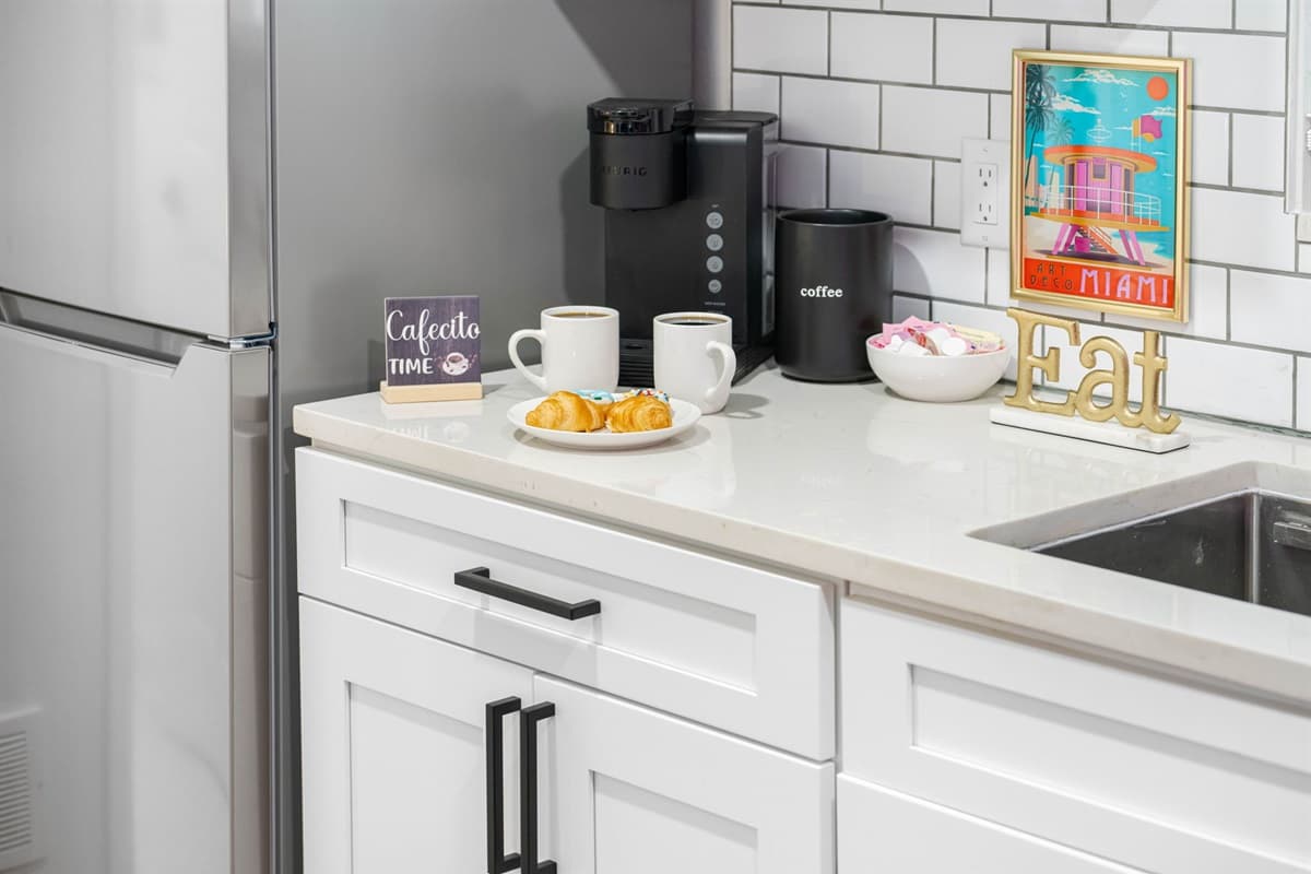 The stainless steel finish of the appliances adds a touch of modern elegance, contrasting beautifully with the all-white decor.