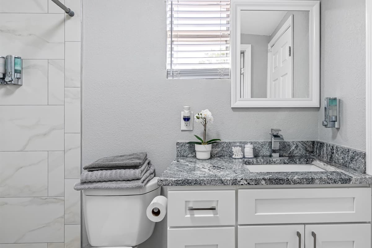 The white tiles in the shower, and light grey painted walls create a crisp and clean backdrop that sets the tone for the entire space.