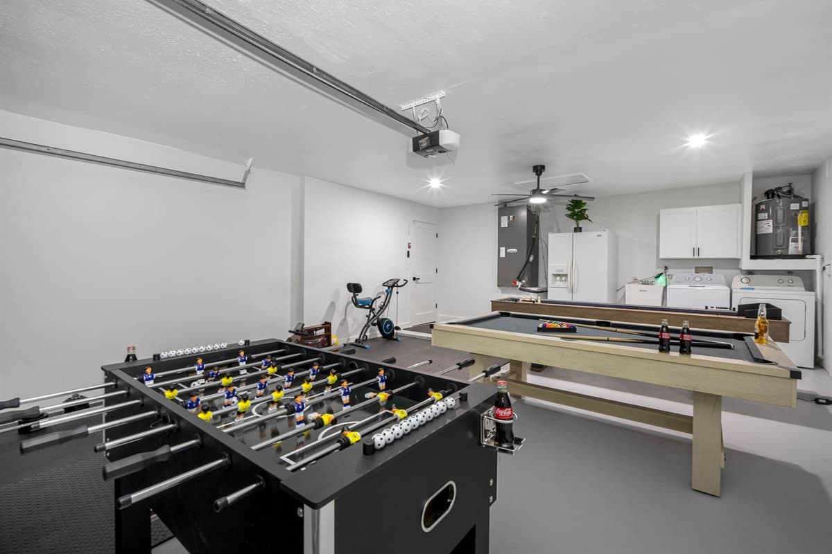 Entertainment meets convenience in this stylish indoor game area with a pool table, foosball, and workout zone — the perfect blend of play and balance.