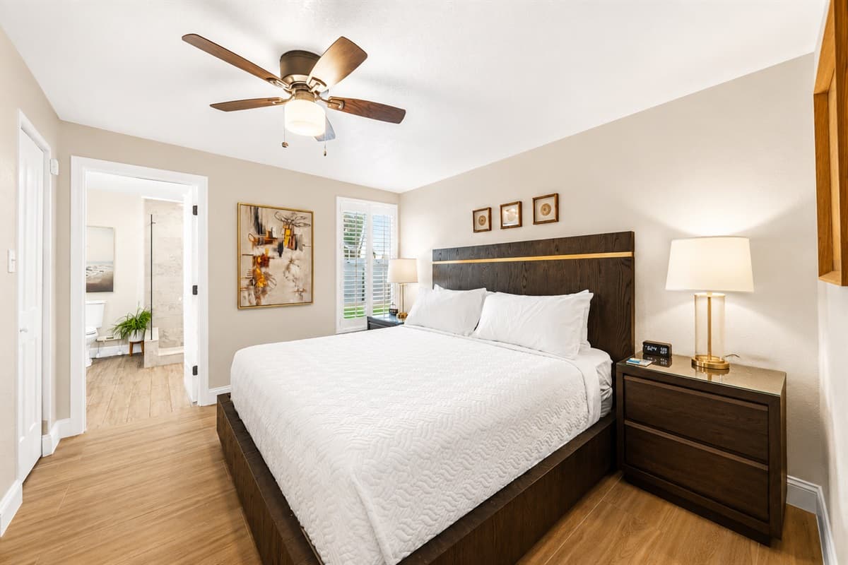 This cozy and beautifully furnished bedroom features a comfortable king-size bed, elegant wood furnishings, and warm natural lighting for a relaxing stay. The