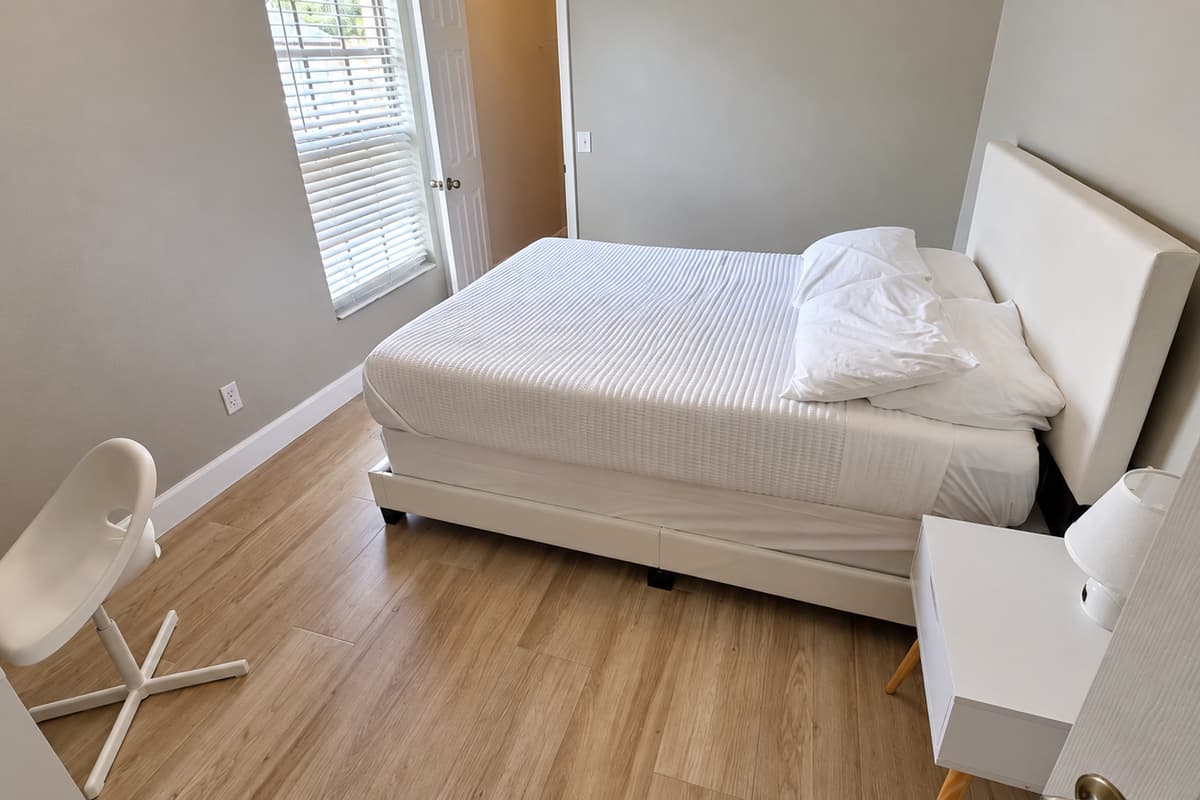 Bright and welcoming bedroom featuring a comfortable bed, modern décor, and plenty of natural light from the large window.