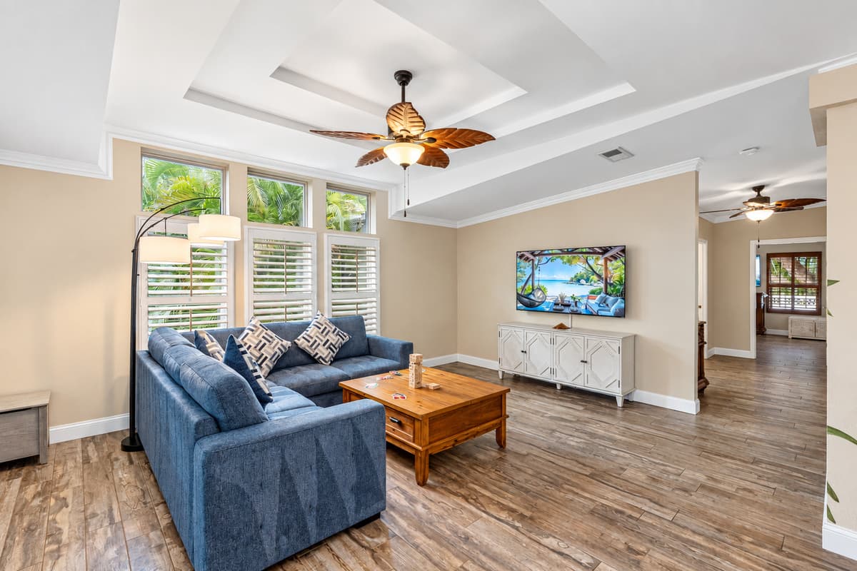 This coastal-inspired living space offers comfort and style, complete with warm natural light, a spacious sectional, and a hand-painted mural that brings the room to life.