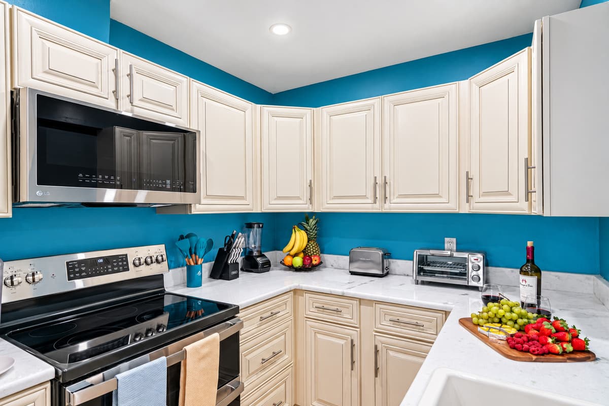 Surrounding the kitchen are pristine white cupboards, providing ample storage for your cookware, utensils, and pantry essentials.