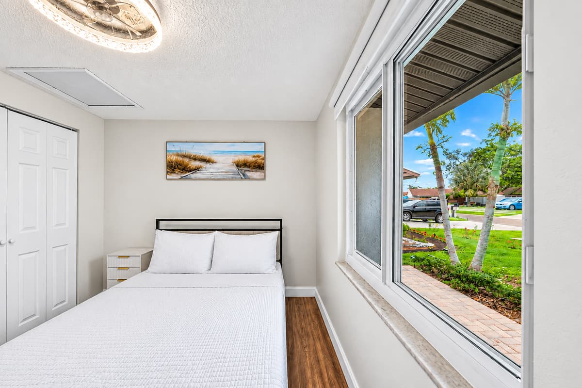 Comfortable queen bedroom overlooking the front yard, offering a relaxing retreat after a day of exploring Tampa.