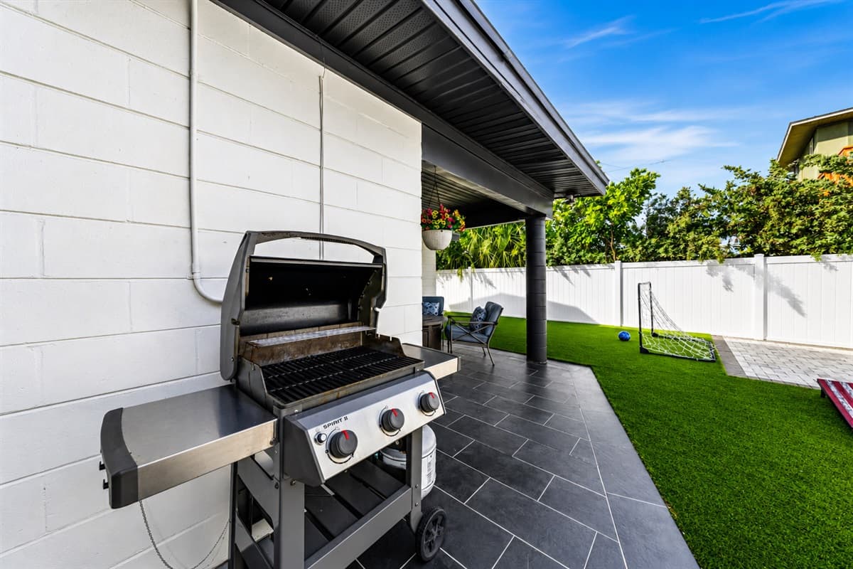 Outdoor grilling station with spacious patio and private backyard recreation area.