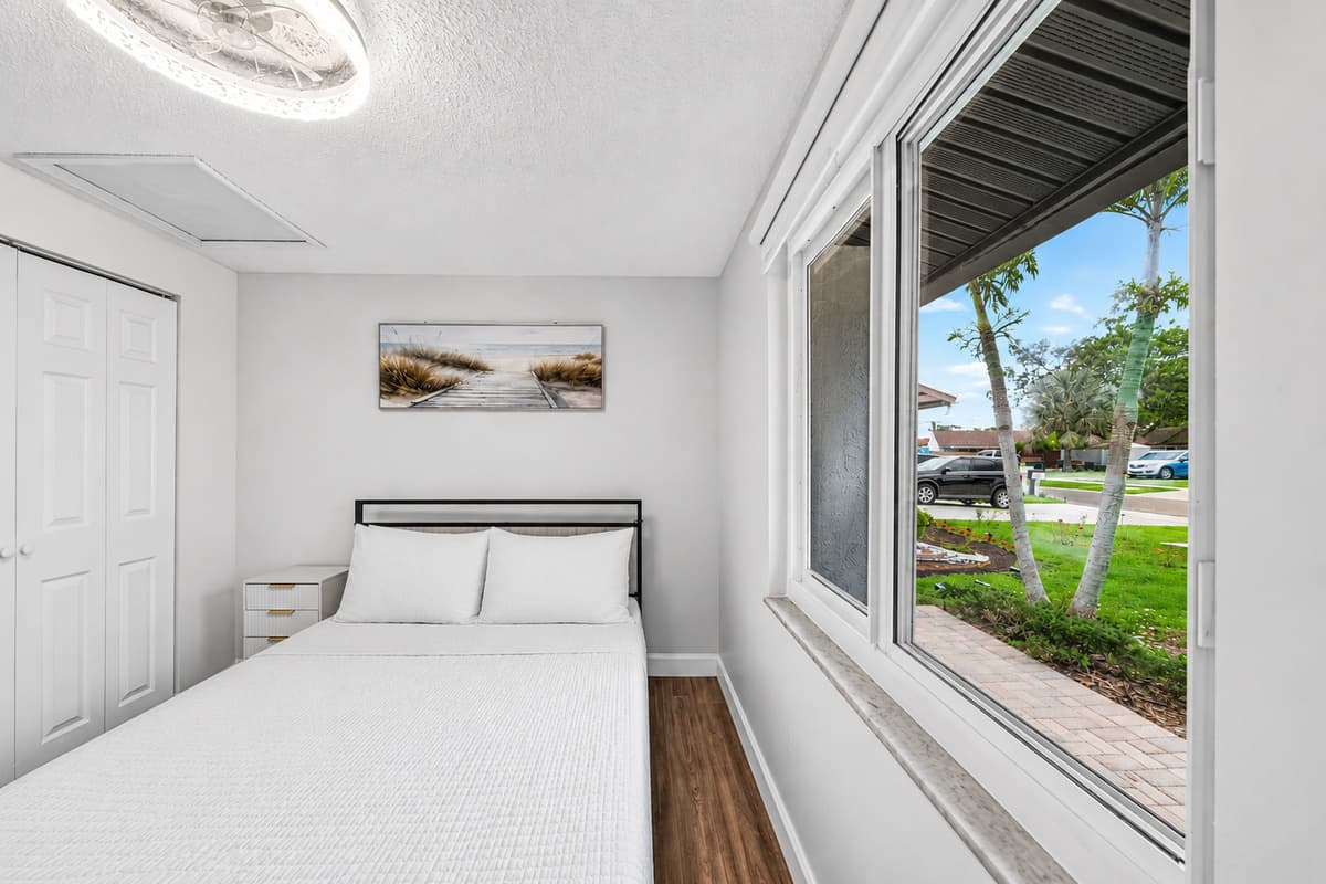 Comfortable queen bedroom overlooking the front yard, offering a relaxing retreat after a day of exploring Tampa.