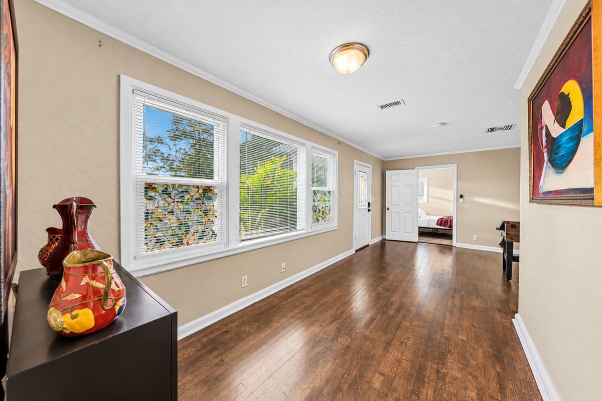 Bright hallway with large windows bringing in natural light and connecting living spaces.