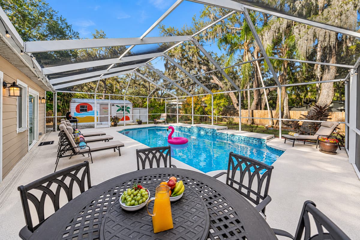 Enjoy outdoor dining by the pool with a shaded patio table, perfect for morning coffee, fresh fruit, or evening meals with family and friends.