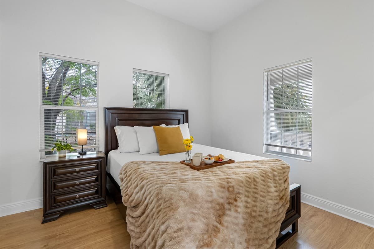 This serene bedroom features a comfortable bed, soft neutral décor, and natural light, creating a calm and inviting retreat.