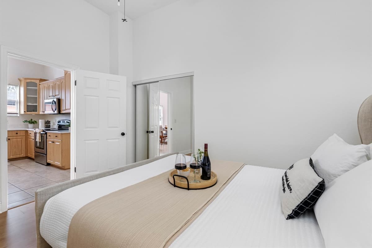 With high ceilings, large windows, and crisp white linens, this bedroom offers a refreshing and relaxing atmosphere perfect for a restful night’s sleep.