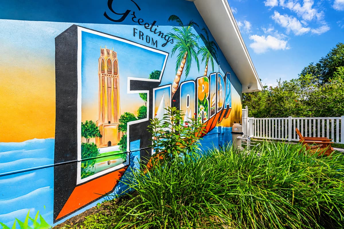 A hand-painted Tampa mural on the back wall. The backyard has a personality before you even sit down.