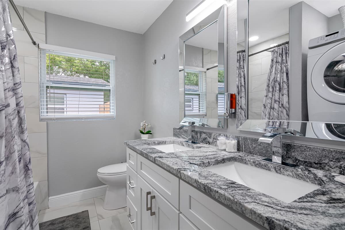 This stunning bathroom has a bathtub, shower, toilet and his and hers sink. It is also equipped with full sized washer and dryer. If you have any questions, send us a message!
