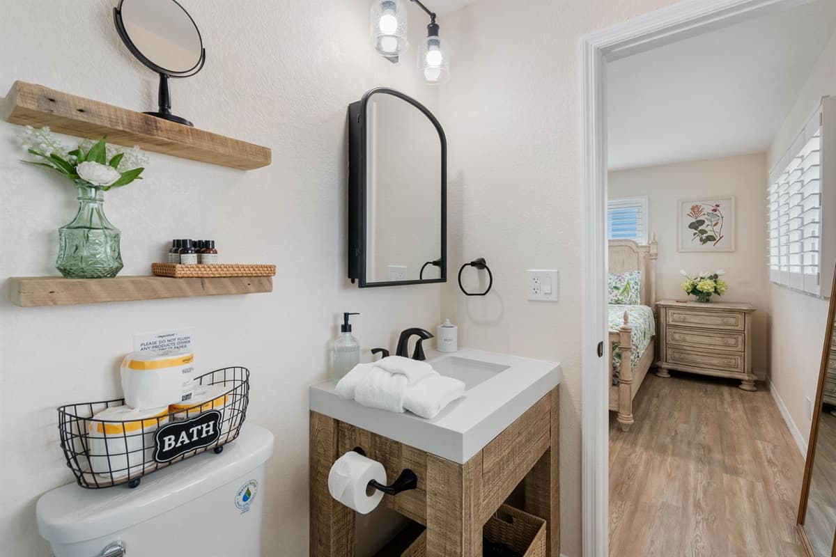 Bedroom 1 Ensuite: The adjoining bathroom boasts a beautiful walk-in shower, sleek black fixtures, and elegant stone-like tile — perfect for refreshing after a day in the sun.