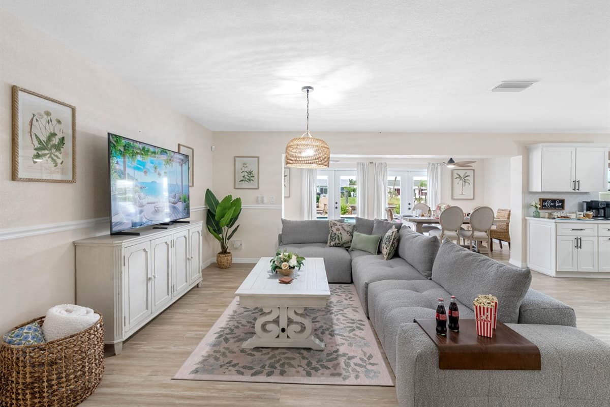 Enjoy the modern open floor plan with a spacious sectional, whitewashed furniture, and stylish accents.