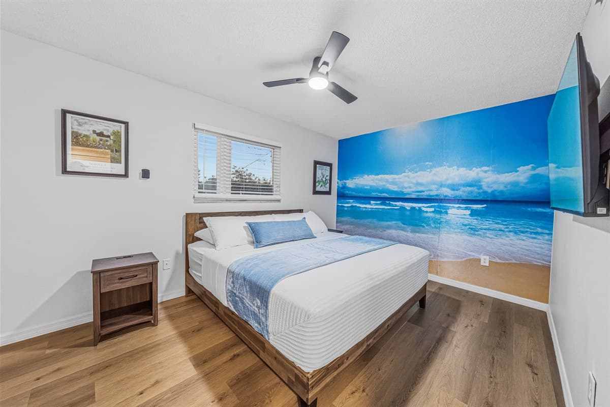 Unique bedroom with a stunning beach-themed accent wall, creating a tranquil coastal vibe 