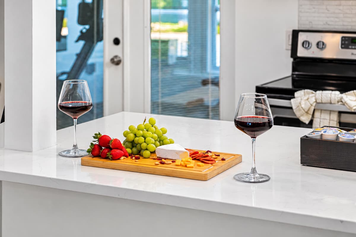Kitchen counter with wine, fresh fruit, and a charcuterie spread.