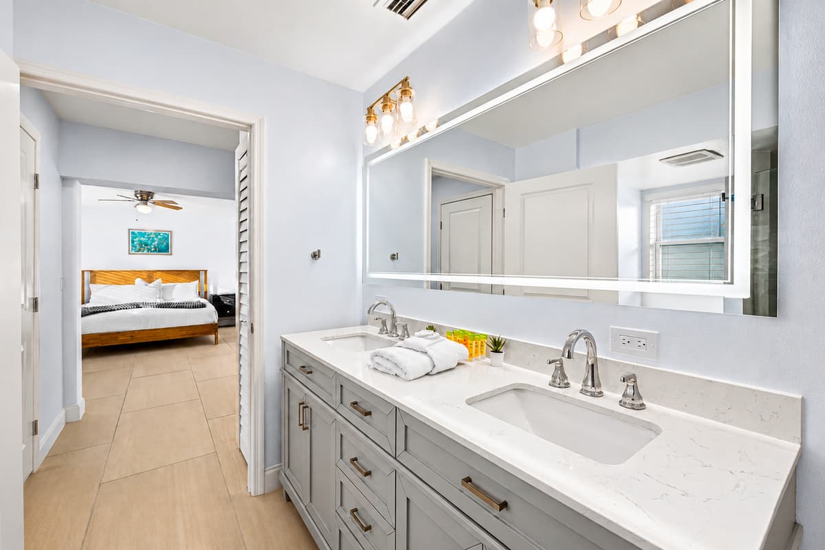 Stylish bathroom vanity with illuminated mirror and direct access to the bedroom suite.