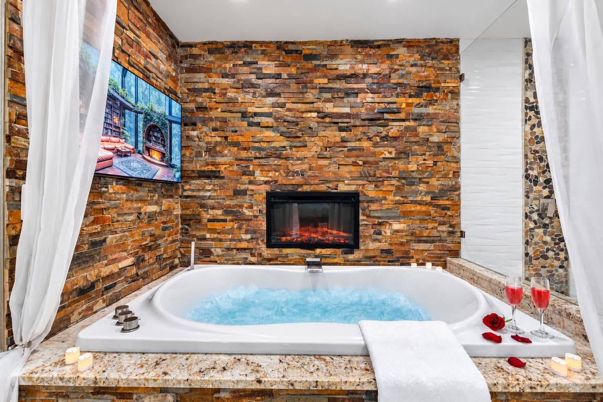 Features a deep soaking tub perfectly positioned in front of a wall-mounted TV, allowing you to unwind with your favorite show or movie as you soak away the day.