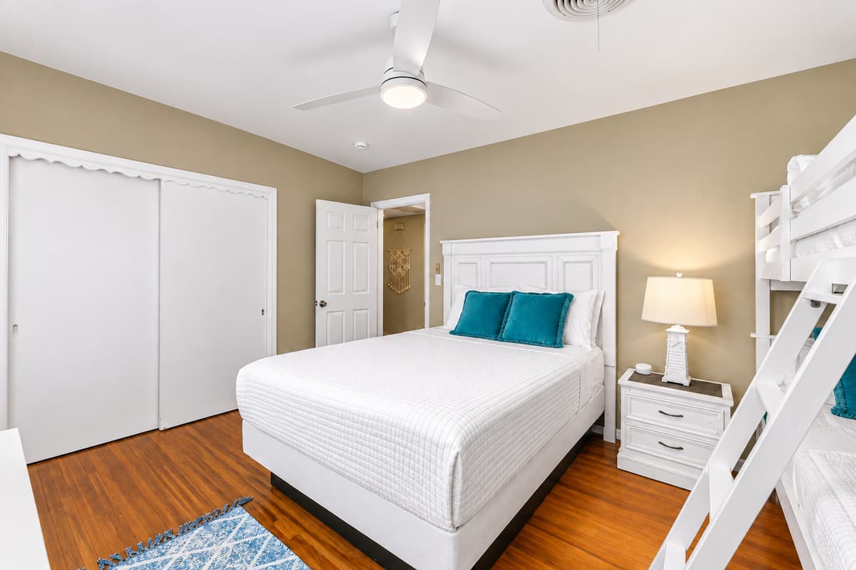 Cozy guest room with modern furnishings, ample closet space, and bunk beds perfect for families.
