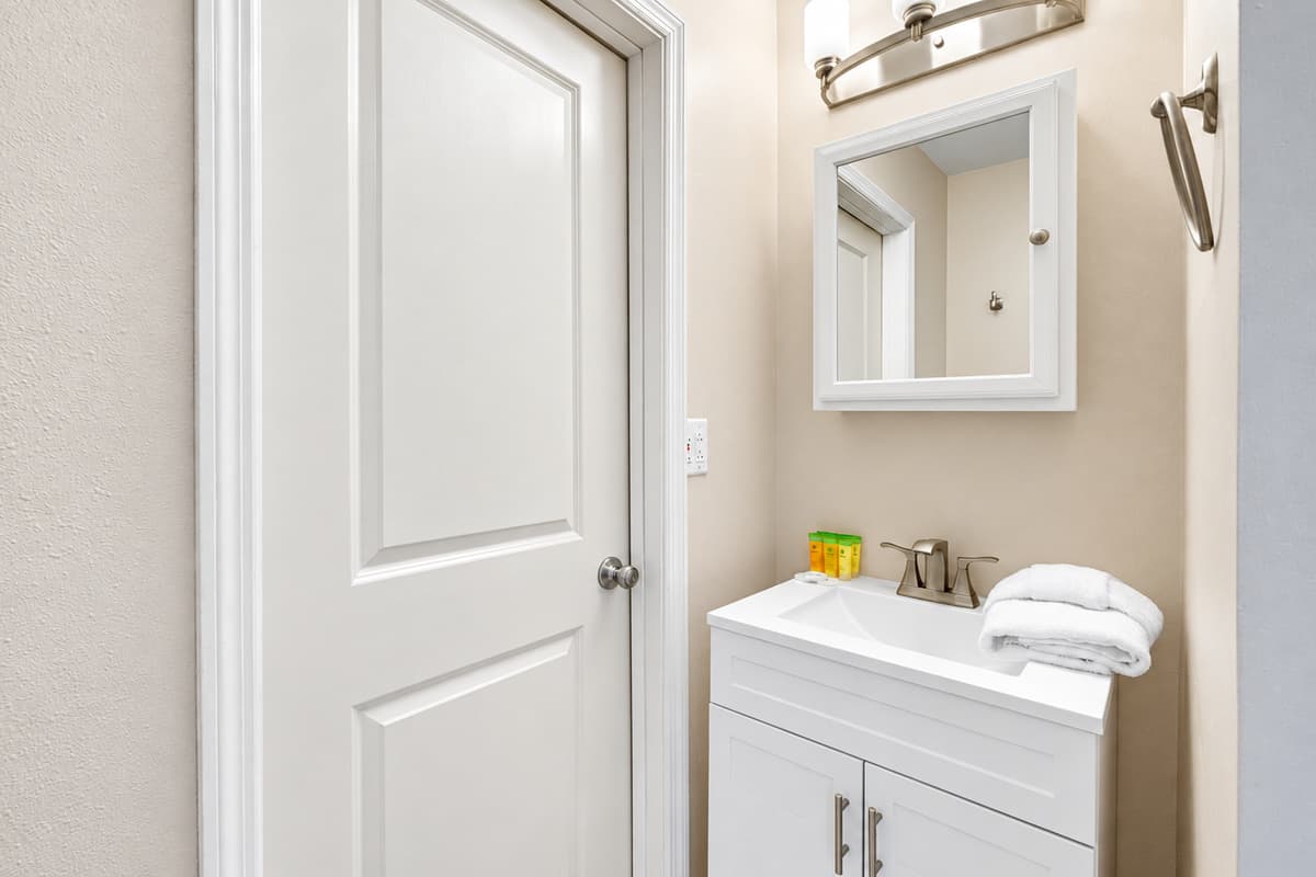 The standout feature is the generously sized walk-in shower, finished in rich natural stone tiles with a textured pebble-style floor.