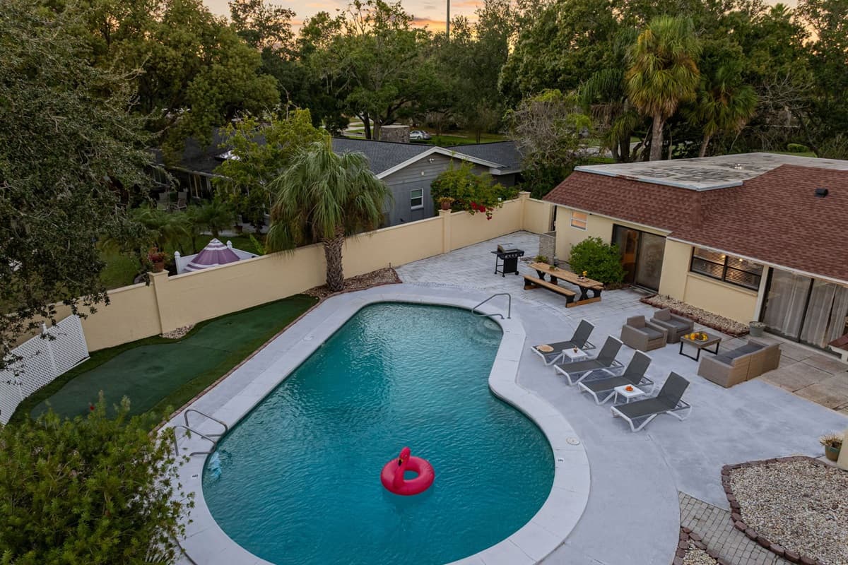 Surrounded by greenery and enclosed for privacy, this pool area offers a peaceful escape with plenty of space to lounge, dine, and unwind.