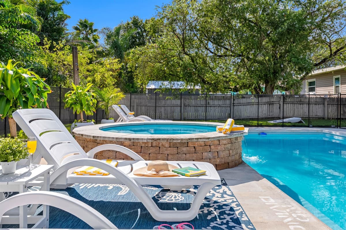 Swim, soak, and lounge in a private backyard paradise complete with string lights and comfortable seating.