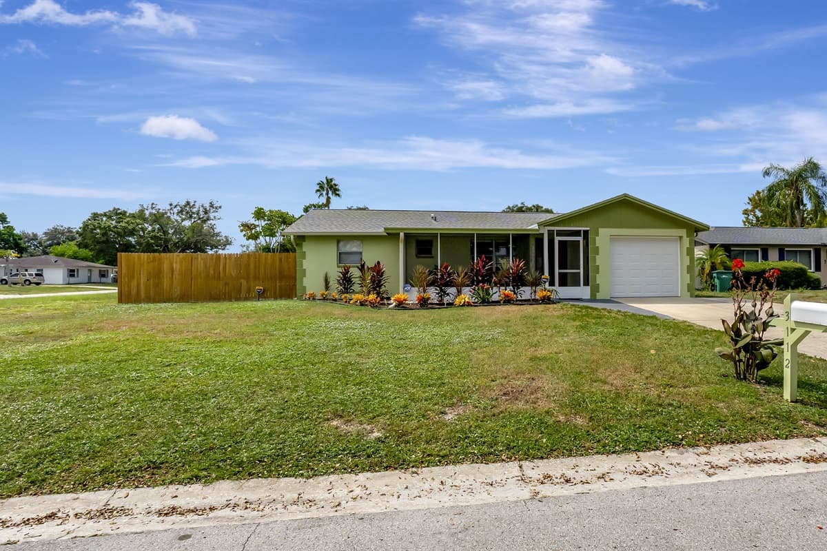 The front lawn and expansive driveway are both picturesque and roomy.